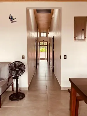 a hallway of a house with white walls and a table at Casa Macaw in Fortuna