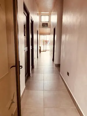 a hallway with a long hall with doors and tile floors at Casa Macaw in Fortuna