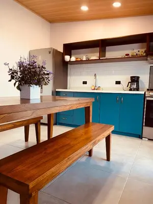 a kitchen with a wooden bench and blue cabinets at Casa Macaw in Fortuna