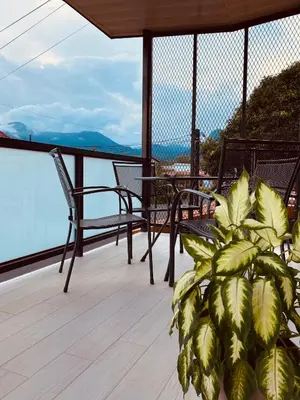 a porch with chairs and a plant on a balcony at Casa Macaw in Fortuna