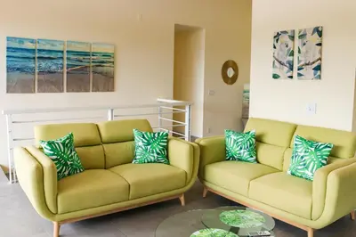 a living room with two chairs and a table at Casa Nalifos in Playa Flamingo