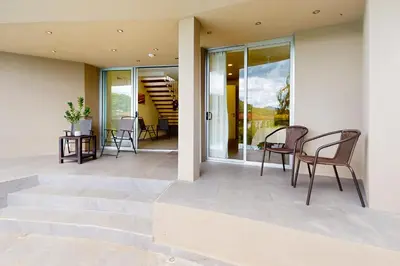 a patio with chairs and stairs in a house at Casa Nalifos in Playa Flamingo