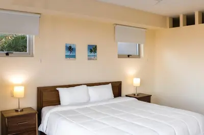 a bedroom with a large white bed with two night stands at Casa Nalifos in Playa Flamingo