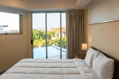 a bedroom with a bed and a large window at Casa Nalifos in Playa Flamingo
