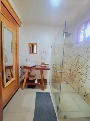 a bathroom with a glass shower and a sink at Colibrí Villa, 800 m from Beach in Uvita