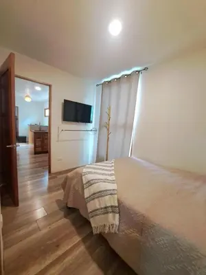 a bedroom with a bed and a flat screen tv at Colibrí Villa, 800 m from Beach in Uvita