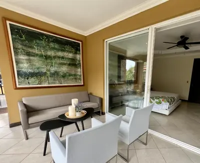a living room with a couch and a table and chairs at Spacious Penthouse with pool & Jungle Views in La Mona