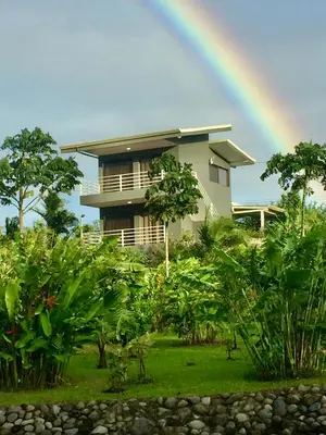 a rainbow in front of a house with at The Fruit Tree Garden Bromeliad Suite in Nuevo Arenal