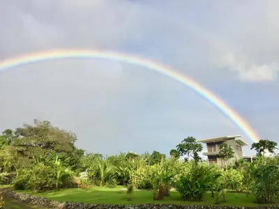 a rainbow in the sky over a house at The Fruit Tree Garden Bromeliad Suite in Nuevo Arenal