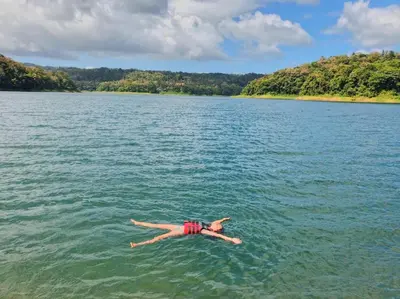 a person laying in the water on a lake at The Fruit Tree Garden Bromeliad Suite in Nuevo Arenal