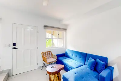 a living room with a blue couch and a chair at Villa Verde I - 3 in Tamarindo