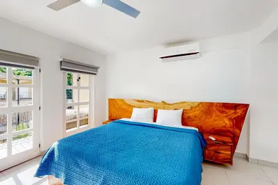 a bedroom with a bed with a blue blanket at Villa Verde I - 3 in Tamarindo
