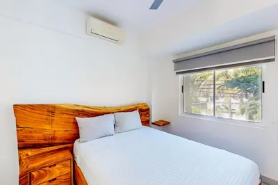 a white bedroom with a bed and a window at Villa Verde I - 3 in Tamarindo