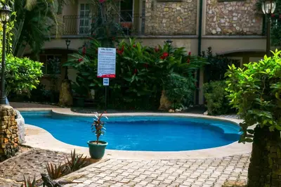 a large blue pool with a sign in front of a building at Villa Verde I - 3 in Tamarindo