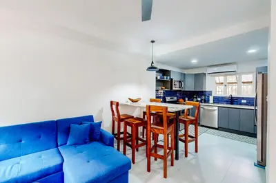a blue couch in a kitchen with a table and chairs at Villa Verde I - 3 in Tamarindo