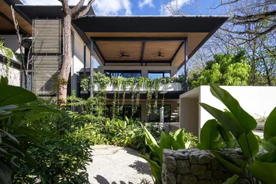 an exterior view of a house with plants at QUIN Surf Residence Nosara in Nosara