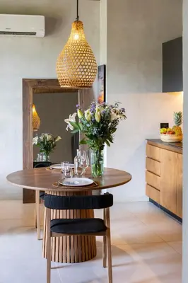 a dining room table with a vase of flowers at QUIN Surf Residence Nosara in Nosara