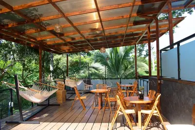 a deck with chairs and tables and hammocks at Palo Alto Glamping Hotel in Quesada