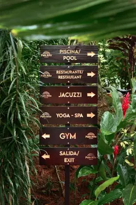a sign in the middle of a garden at Palo Alto Glamping Hotel in Quesada