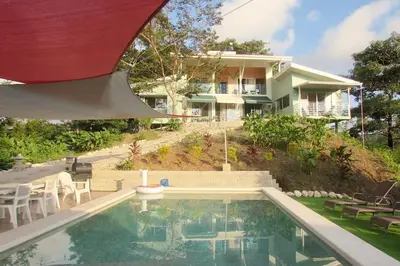a house with a swimming pool in front of a house at Boutique Tropical Retreat, Sleeps 10, Perfect for Friends and Fams in Sámara