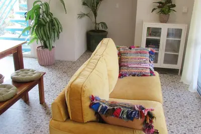 a yellow couch in a living room with plants at Boutique Tropical Retreat, Sleeps 10, Perfect for Friends and Fams in Sámara