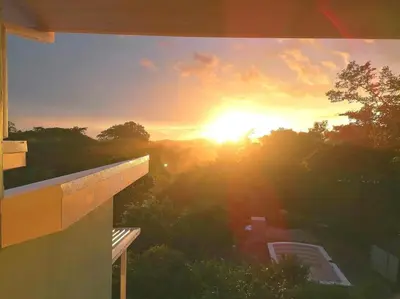 a sunset seen from a window of a building at Boutique Tropical Retreat, Sleeps 10, Perfect for Friends and Fams in Sámara