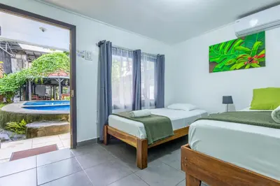 a bedroom with two beds and a view of a pool at La Casona Eco-Lodge Tortuguero in Tortuguero