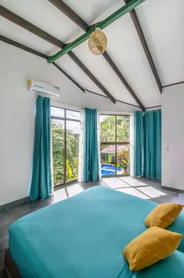 a bedroom with a large blue bed with blue curtains at La Casona Eco-Lodge Tortuguero in Tortuguero