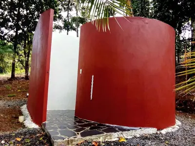 a red door sitting next to a white wall at Volcano Tenorio Glamping Ranch - 3 Tents in Rio Celeste