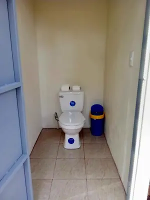 a small bathroom with a toilet and a trash can at Volcano Tenorio Glamping Ranch - 3 Tents in Rio Celeste