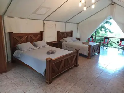 a bedroom with two beds in a tent at Volcano Tenorio Glamping Ranch - 3 Tents in Rio Celeste