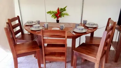 a wooden table with chairs and plates and a plant at Volcano Tenorio Glamping Ranch - 3 Tents in Rio Celeste
