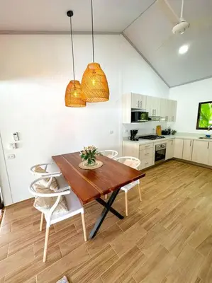 a kitchen with a wooden table and chairs at Casa Garza, con a/c y wifi in Quepos