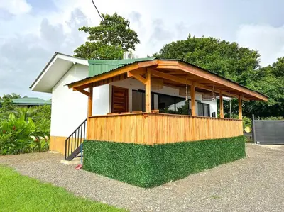 a small house with a wooden roof at Casa Garza, con a/c y wifi in Quepos
