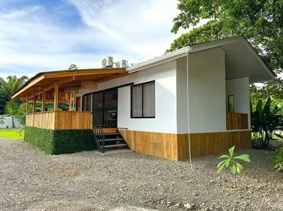 a small house with a gambrel roof at Casa Garza, con a/c y wifi in Quepos