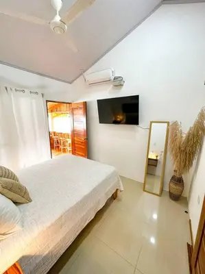 a bedroom with a large bed and a mirror at Casa Garza, con a/c y wifi in Quepos