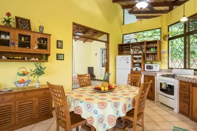 a kitchen with a table and chairs in a room at Kiskadee Casa in Quepos