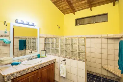a bathroom with a sink and a mirror at Kiskadee Casa in Quepos