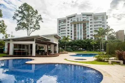a resort with two pools and a building at Luxury NEW Apt -24/7 sec- 10 min from SJO Airport in Heredia