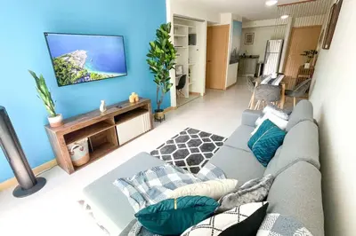 a living room with a couch and a flat screen tv at Luxury NEW Apt -24/7 sec- 10 min from SJO Airport in Heredia