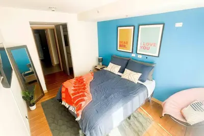 a bedroom with blue walls and a bed with an orange blanket at Luxury NEW Apt -24/7 sec- 10 min from SJO Airport in Heredia