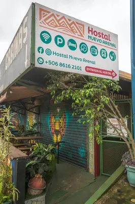 a building with a sign on the side of it at Hostal Nuevo Arenal downtown, private rooms with bathroom in Nuevo Arenal