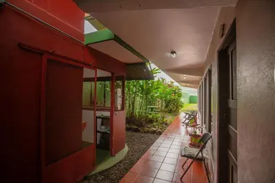 a hallway of a house with a red wall at Hostal Nuevo Arenal downtown, private rooms with bathroom in Nuevo Arenal