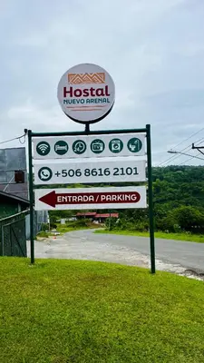 a sign for an emergency parking sign next to a road at Hostal Nuevo Arenal downtown, private rooms with bathroom in Nuevo Arenal