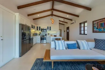 a living room with a white couch and a kitchen at 4 Bedroom Complex At Las Catalinas in Playa Danta