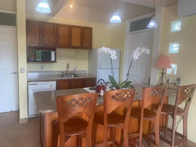 a kitchen with a table with chairs and a vase of flowers at Buena Vista Coco in Coco