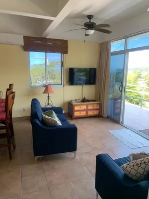 a living room with two blue couches and a tv at Buena Vista Coco in Coco