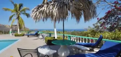 a patio with chairs and a table and an umbrella at Buena Vista Coco in Coco