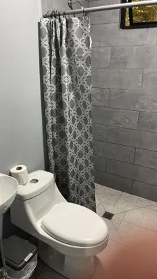 a bathroom with a toilet and a shower curtain at Villas Anna Bertha 2 noches minimo in San Isidro