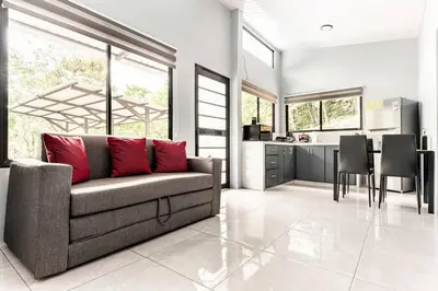 a living room with a couch and a kitchen at Villas Anna Bertha 2 noches minimo in San Isidro